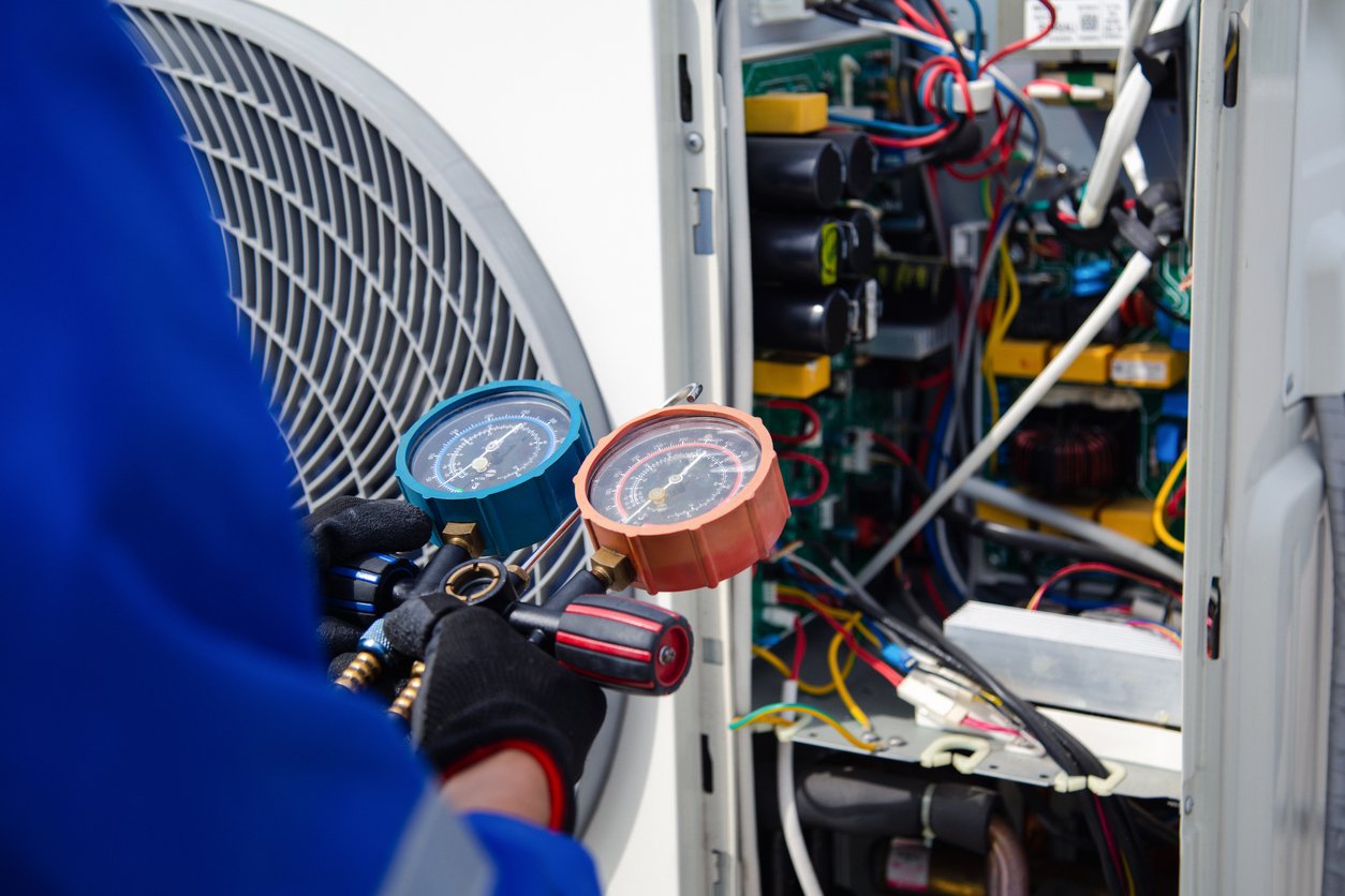 Cool Jay’s Air Conditioning technician inspecting a heating unit for safety and efficiency in Bakersfield